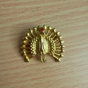 Peacock brooch, gold tone with red rhinestone. 1.5” wide & approximately 1” tall